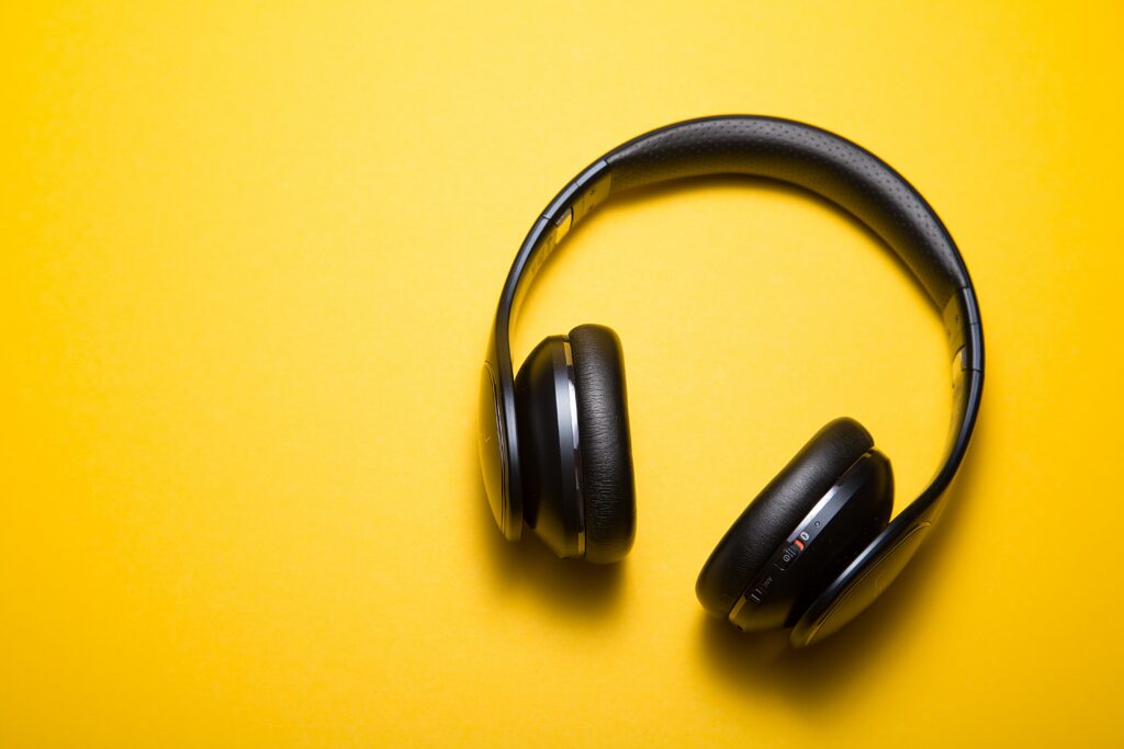 Black headphones against a plain yellow background