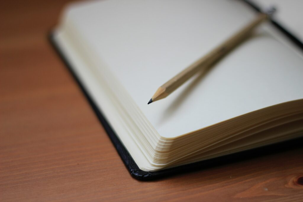 Close-up of a blank open note book with a pencil on top