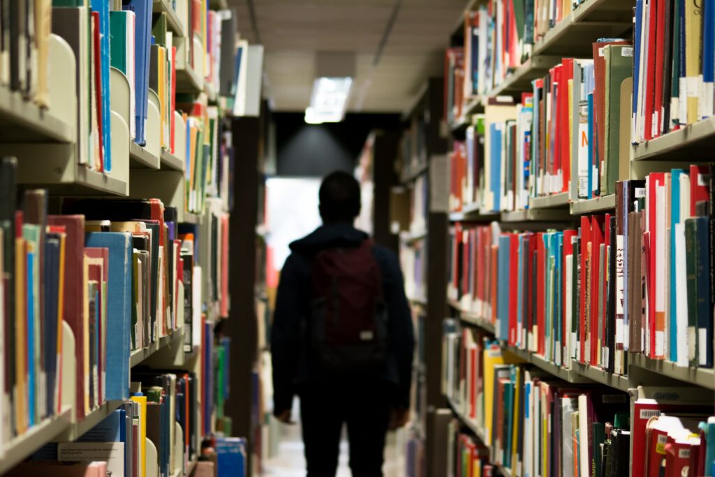A student standing in a library aisle