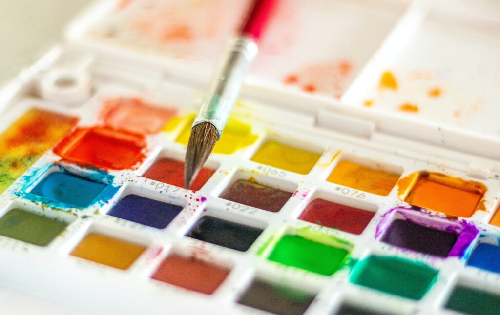 Close-up of a colourful paint palette and paintbrush