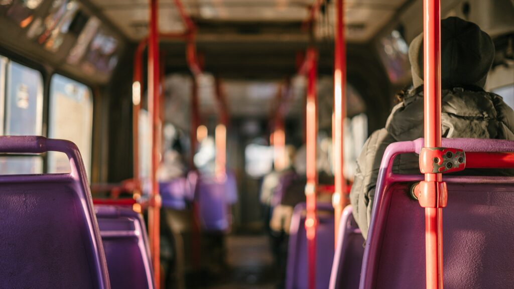 View of a bus aisle and close-up of a person sitting on the bus.