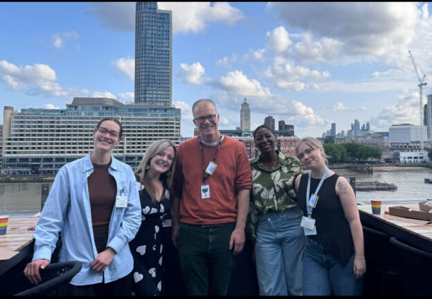 group of people with a riverside view behind them