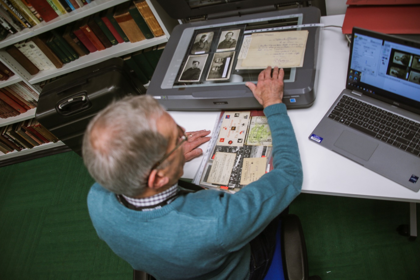 man scanning photos in library