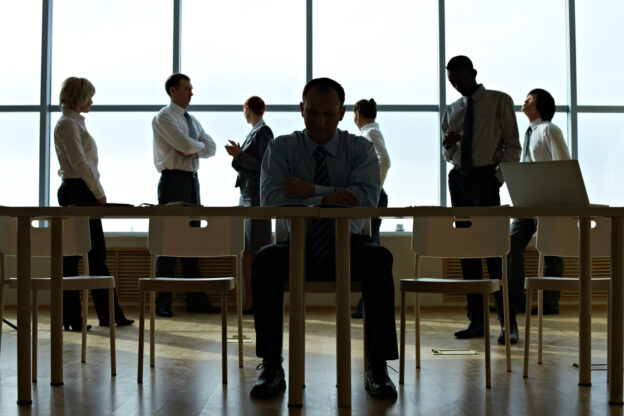 Businessman busy with documents with his colleagues in the background