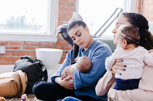 ‘ young mothers sit and listen to the unseen speaker who came to their support group
