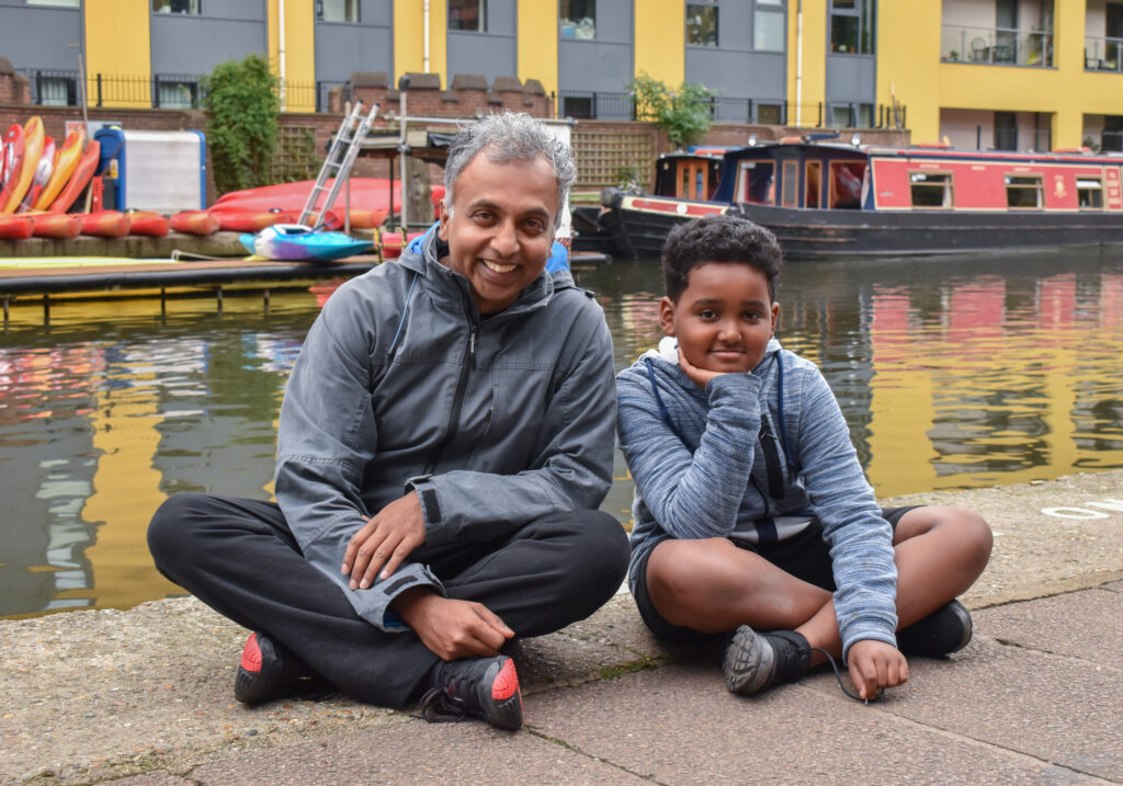 mentor and child sitting near canal